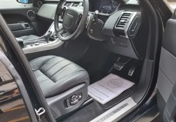 Immaculately detailed interior of a Range Rover, showcasing clean black leather seats and polished controls.